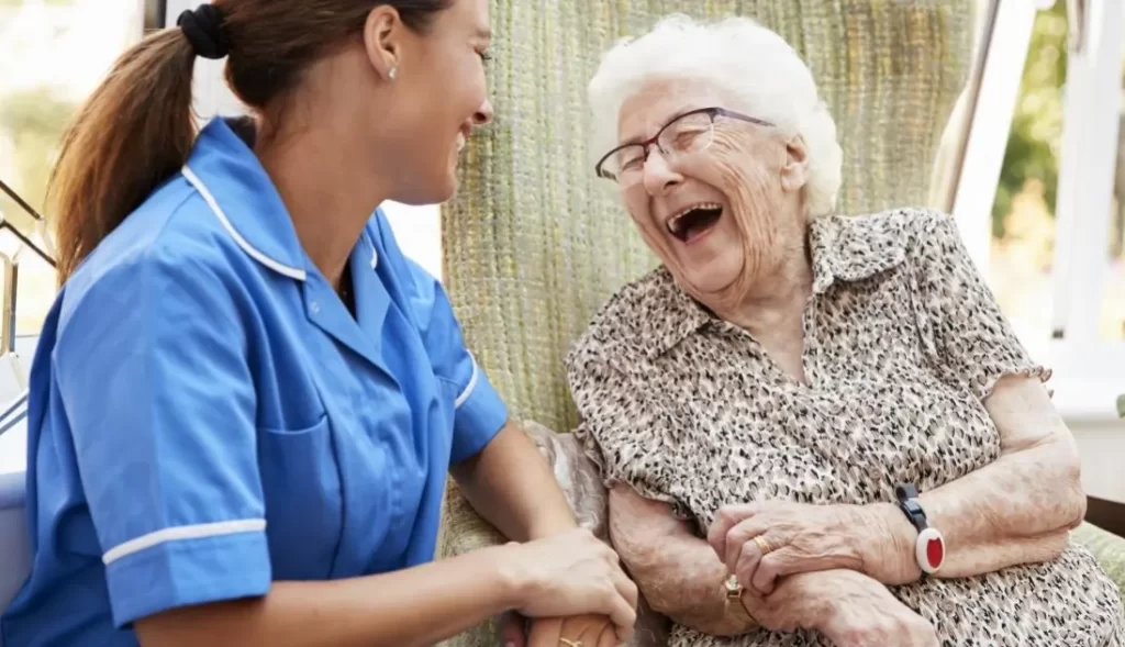 Caregiver warmly engaging with elderly patient